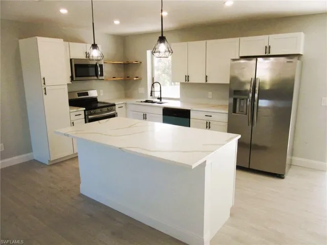 Kitchen featuring stainless steel appliances, white cabinets, open shelves, pendant lighting, and recessed lighting