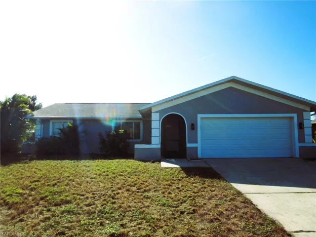 Single story home with stucco siding, concrete driveway, and an attached garage