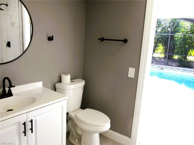 Bathroom featuring vanity, a textured wall, and light tile patterned floors