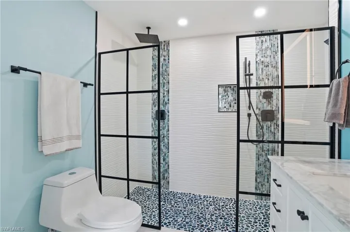 Bathroom with vanity, a walk in shower, and recessed lighting