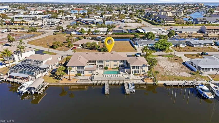 Aerial view of property and surrounding area featuring basin, dock and slips