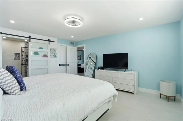 Bedroom featuring a barn door and recessed lighting