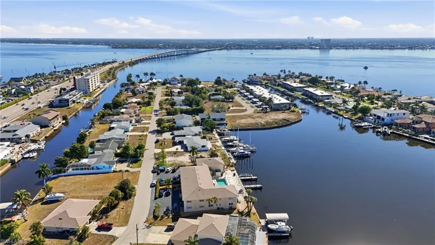 Aerial view of property and surrounding area with nearby suburban area, a notable bridge, and a large body of water
