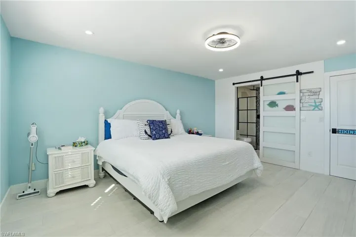 Bedroom featuring a barn door and recessed lighting