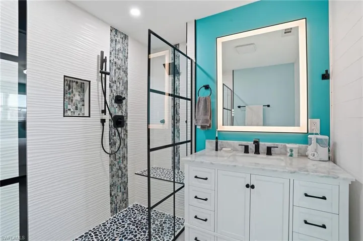 Full bathroom featuring vanity, walk in shower, and recessed lighting