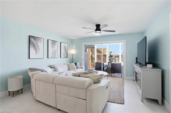 Living area featuring a ceiling fan and baseboards