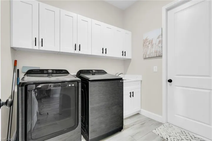 Laundry room featuring cabinet space, baseboards, and washer and clothes dryer