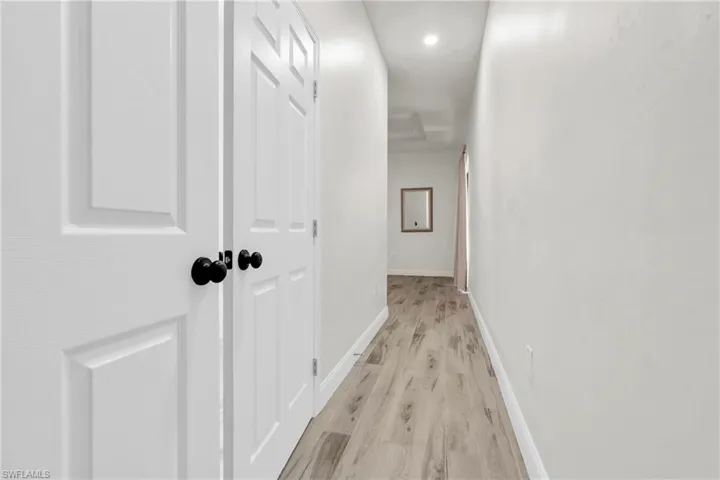 Hall with light wood finished floors and baseboards