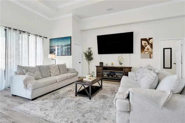 Living room featuring ornamental molding, wood finished floors, and visible vents