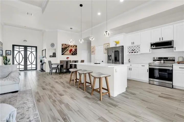Kitchen featuring stainless steel appliances, a center island, visible vents, a kitchen bar, and a high ceiling