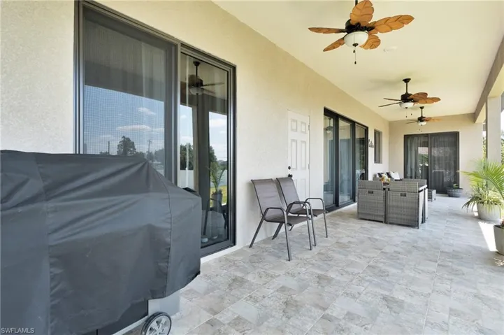 View of patio with outdoor dining area, ceiling fan, and area for grilling