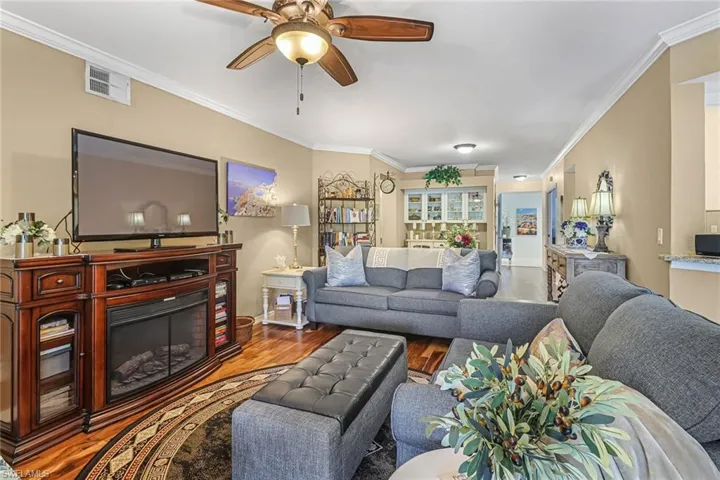 Living room with crown molding, ceiling fan, and hardwood / wood-style floors