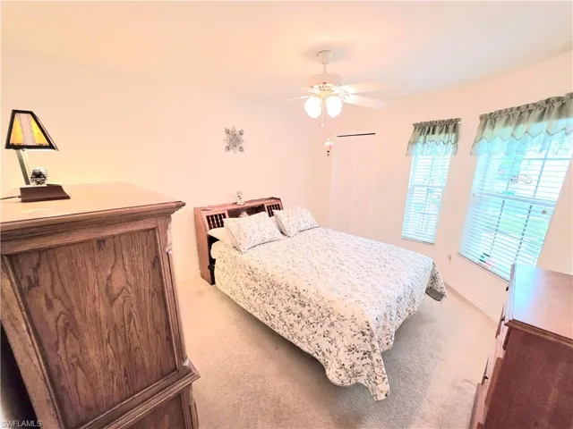 Bedroom featuring light colored carpet, ceiling fan, and a closet