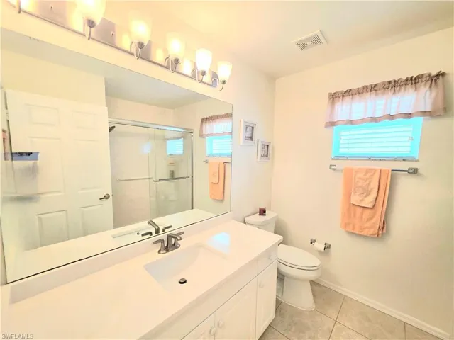 Bathroom featuring vanity, a stall shower, and light tile patterned flooring