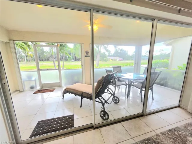 Sunroom / solarium featuring tile patterned flooring, a ceiling fan, and outdoor dining area