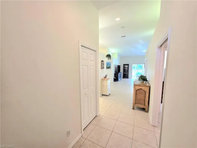 Corridor featuring light tile and recessed lighting
