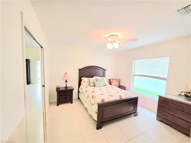 Bedroom with light tile patterned flooring and ceiling fan