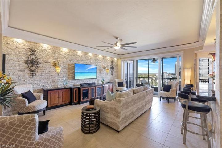 Great room with bar open to kitchen and screened balcony in the rear