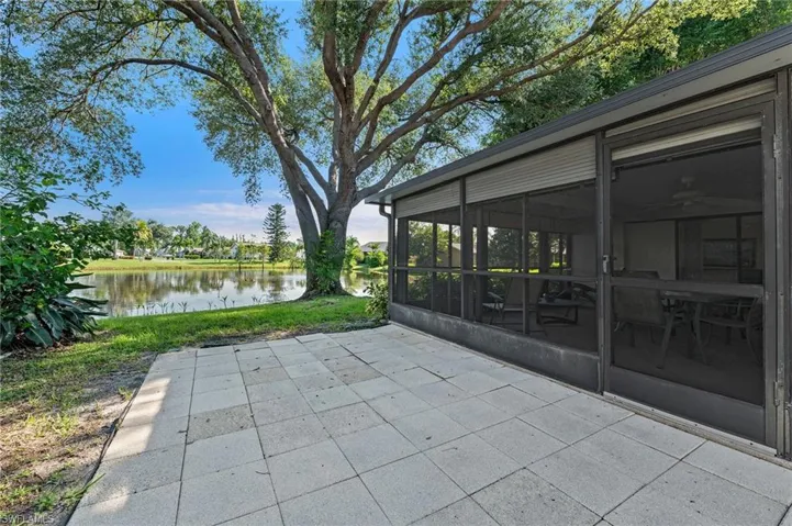 View of patio with a sunroom and a water view