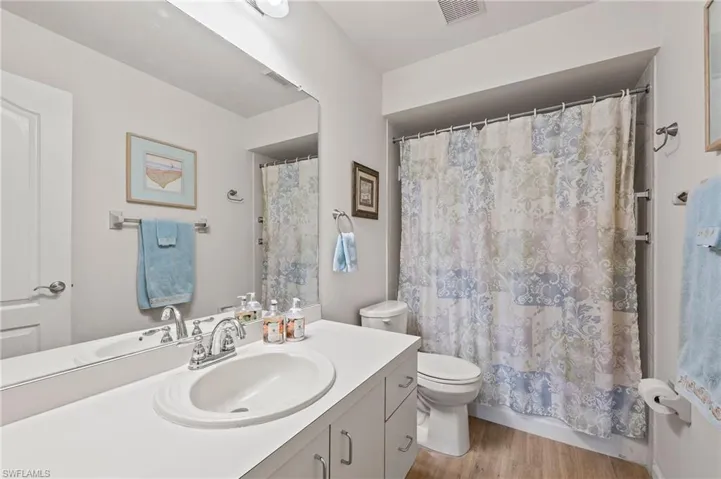 Bathroom featuring toilet, hardwood / wood-style floors, and vanity