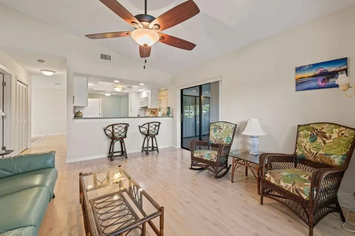 Living room featuring ceiling fan, light hardwood / wood-style floors, and lofted ceiling
