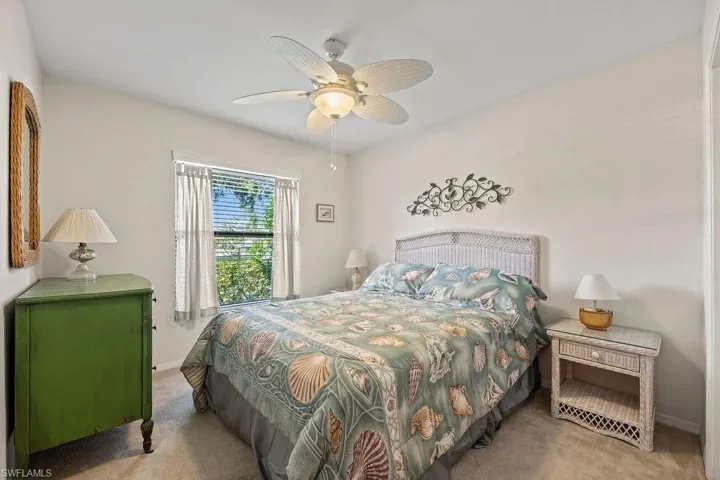 Carpeted bedroom featuring ceiling fan