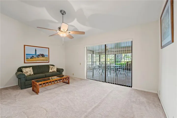 Carpeted living room with ceiling fan