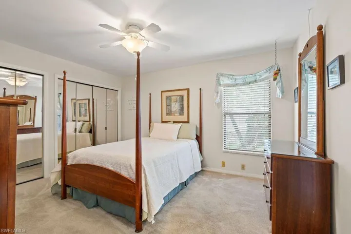 Bedroom with a closet, ceiling fan, and light colored carpet