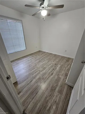 Empty room with hardwood / wood-style floors and ceiling fan