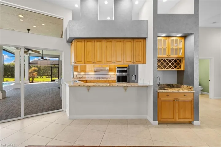 Kitchen with wood-finish cabinetry, granite countertops, and built-in appliances