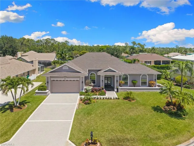 Contemporary residence featuring a paved driveway, two-car garage, and established landscaping