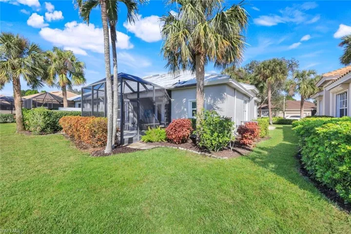 Back of house featuring a lanai and a lawn