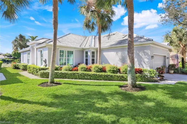 View of property exterior featuring a garage and a lawn