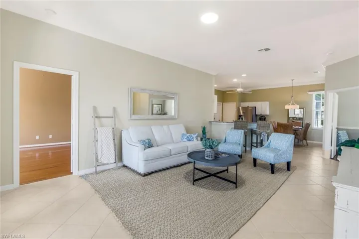 Tiled living room with crown molding and ceiling fan