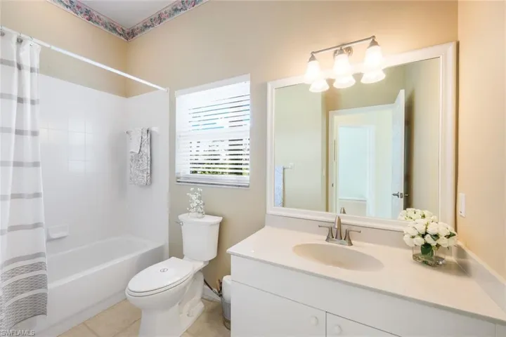 Full bathroom featuring vanity, tile patterned floors, shower / bath combination with curtain, and toilet