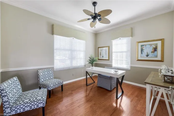 Office area with crown molding, ceiling fan, and hardwood / wood-style floors