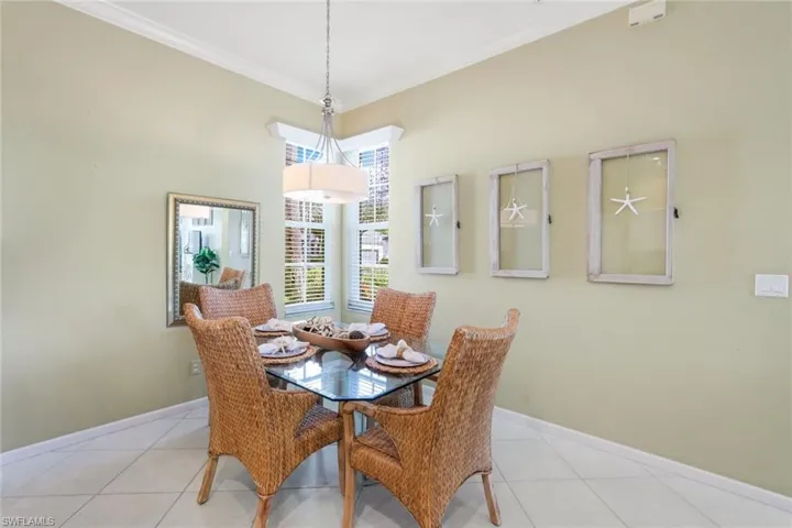 Dining area featuring light tile patterned flooring and crown molding