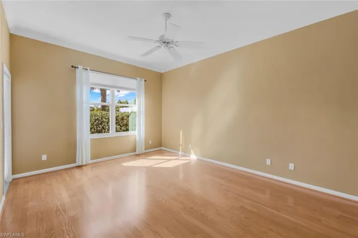 Empty room featuring crown molding, light hardwood / wood-style floors, and ceiling fan