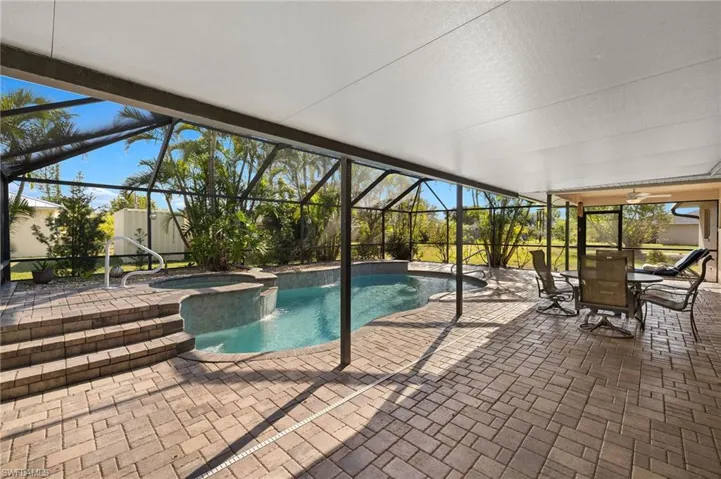 View of swimming pool with outdoor dining area, a patio area, a lanai, and a pool with connected hot tub