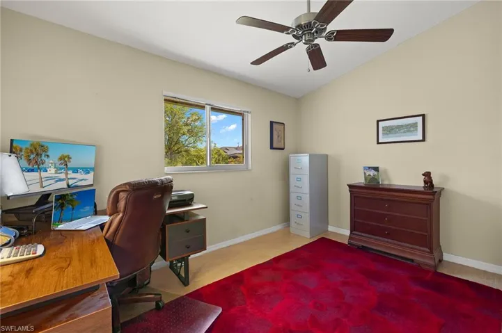 Office with lofted ceiling, baseboards, and a ceiling fan