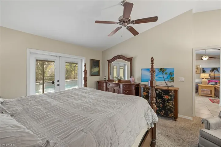 Bedroom with access to exterior, french doors, light carpet, vaulted ceiling, and ceiling fan