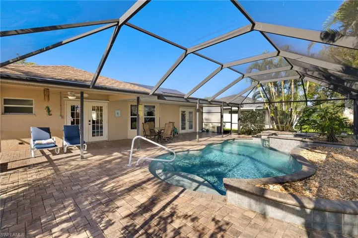 View of pool with glass enclosure, a patio, and french doors