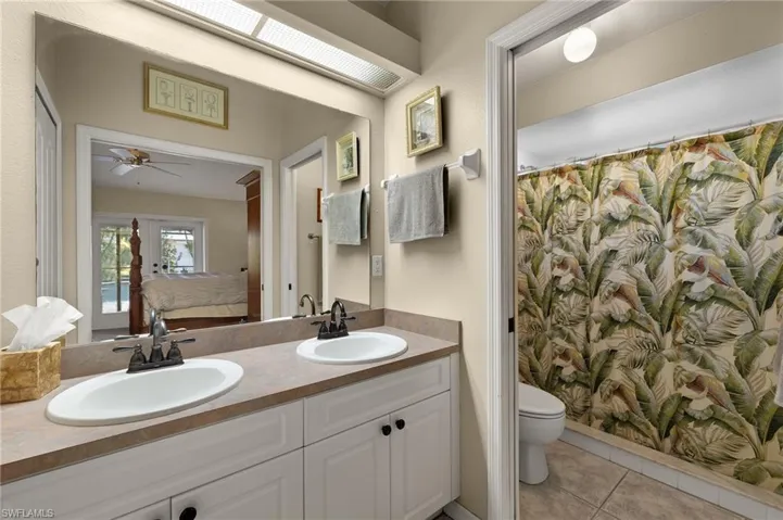 Full bath with connected bathroom, a sink, toilet, and tile patterned floors