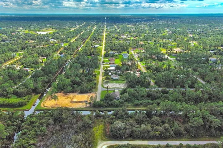 Aerial view of property and surrounding area featuring a nearby body of water