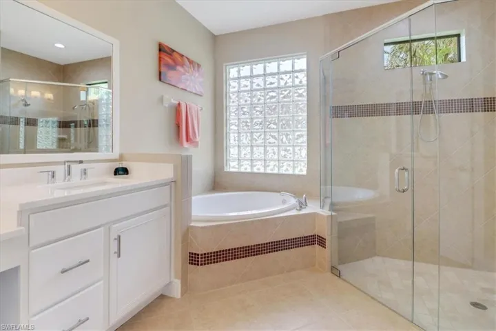 Bathroom featuring shower with separate bathtub, vanity, tile patterned floors, and plenty of natural light