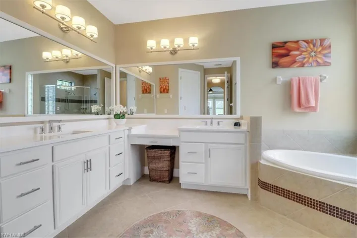 Bathroom with tile patterned flooring, shower with separate bathtub, and vanity