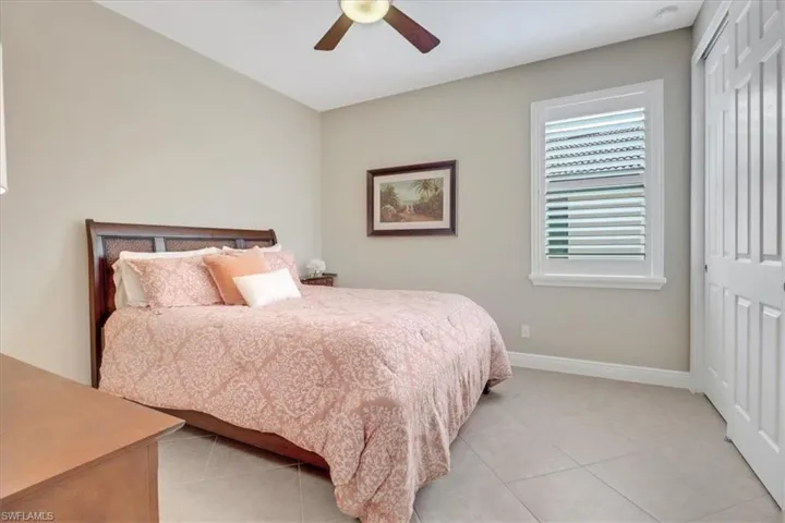 Bedroom featuring ceiling fan, light tile patterned flooring, and a closet