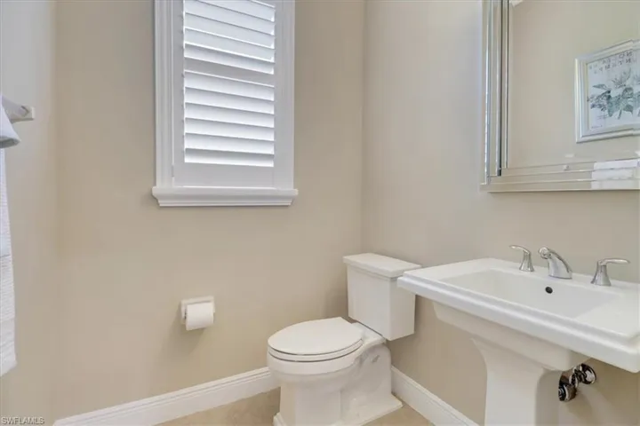 Bathroom featuring tile patterned flooring, toilet, and sink