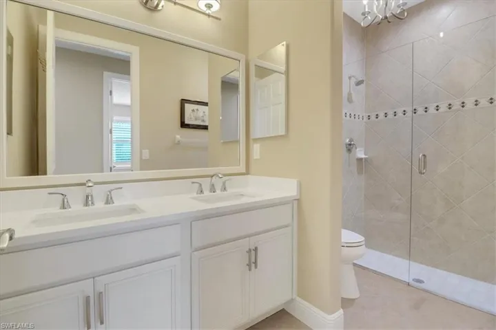 Bathroom with vanity, toilet, and an enclosed shower