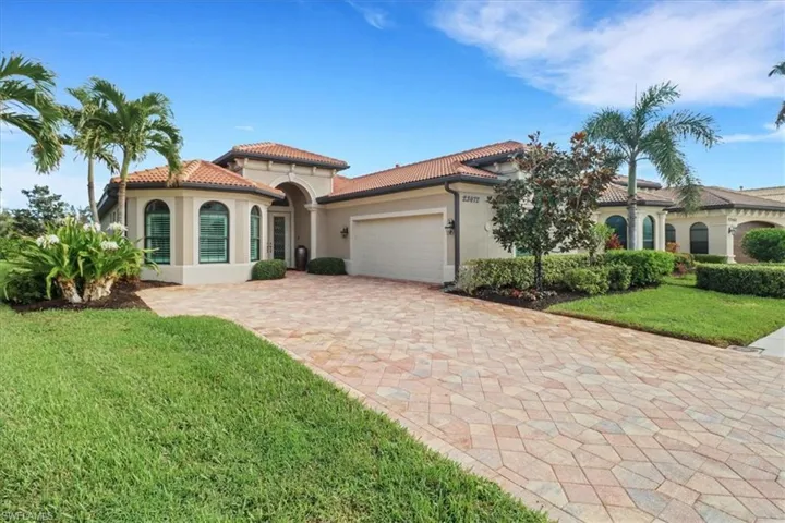 Mediterranean / spanish house featuring a front yard and a garage
